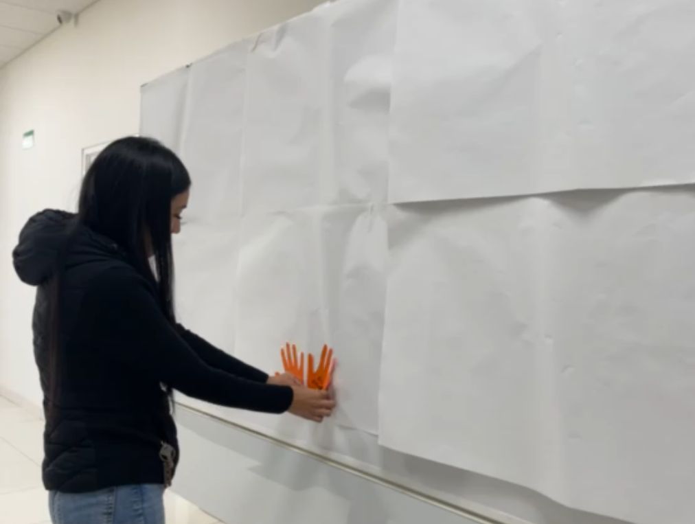 mujeres participan en Mural con Manos Naranjas del IEC.jpeg