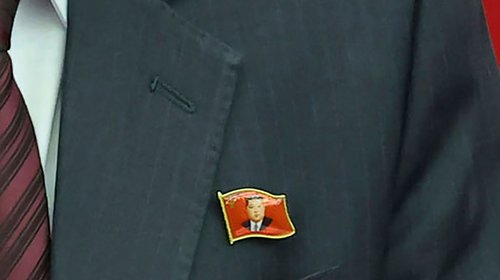 Funcionarios norcoreanos exhiben prendedores de Kim Jong Un
